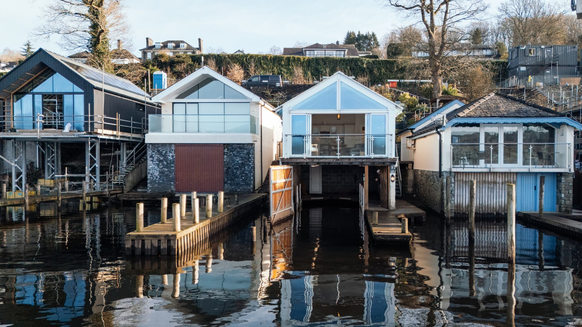 Waterside holiday boathouses on a calm lake at golden hour